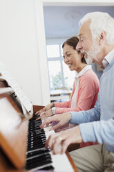 Active senior couple playing piano - CAIF22218