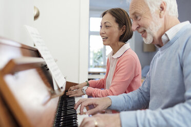 Active senior couple playing piano - CAIF22226