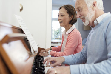 Aktives Seniorenpaar spielt Klavier - CAIF22226