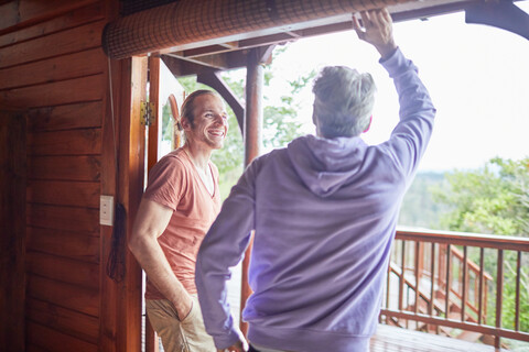Vater und Sohn unterhalten sich an der Terrassentür der Hütte, lizenzfreies Stockfoto
