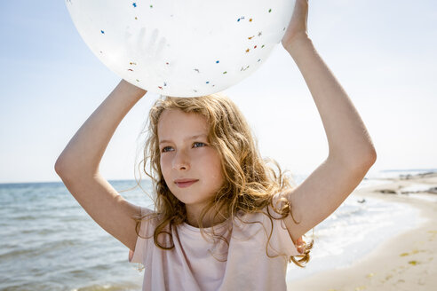 Mädchen hält einen Luftballon am Strand - OJF00286