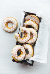 Cake pan of homemade doughnuts with icing and sugar beads - IPF00488