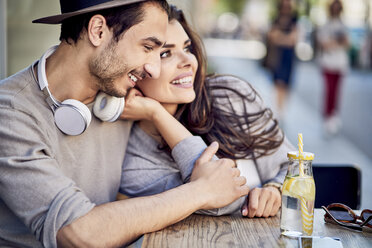 Happy affectionate young couple at outdoors cafe - BSZF00791