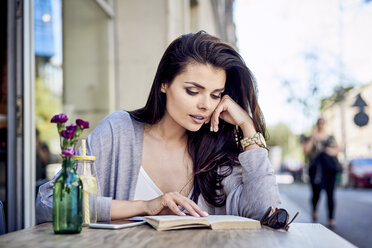 Frau liest Buch in einem Café im Freien - BSZF00795