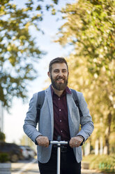 Portrait of smiling businessman with scooter - ZEDF01714