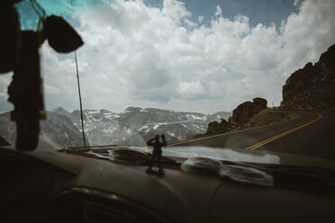 Auto auf Bergstraße gegen bewölkten Himmel im Rocky Mountain National Park - CAVF51503