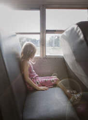 Seitenansicht eines Mädchens mit blonden Haaren, das in einem Bus am Fenster sitzt - CAVF51512