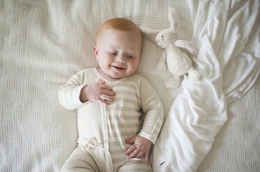 Draufsicht auf einen niedlichen kleinen Jungen auf dem Bett liegend - CAVF51555