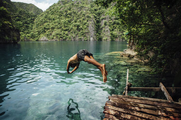 Full length of shirtless man diving into sea against mountains - CAVF51633