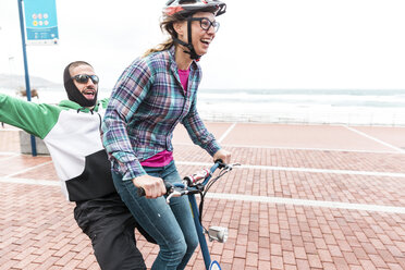 Friends enjoying bicycle ride on promenade - CAVF51655