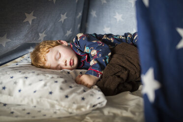 Nahaufnahme eines süßen Jungen, der zu Hause auf dem Bett im Zelt schläft - CAVF51662