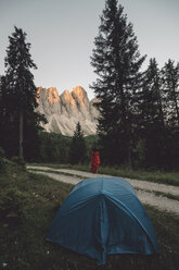 High angle view of young woman standing by tent against mountains - CAVF51691