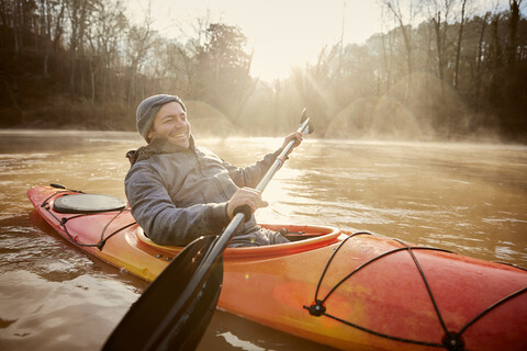 Lächelnder Mann im Kajak auf dem Chattahoochee River gegen den Himmel, lizenzfreies Stockfoto