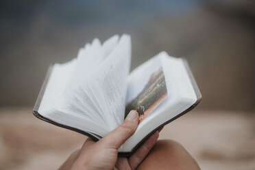 Abgeschnittene Hand einer Frau, die ein Buch im Grand Canyon National Park hält - CAVF51816
