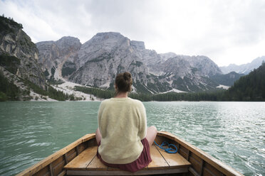 Rückansicht einer Frau, die in einem Boot auf einem Fluss inmitten eines Berges vor dem Himmel sitzt - CAVF51854