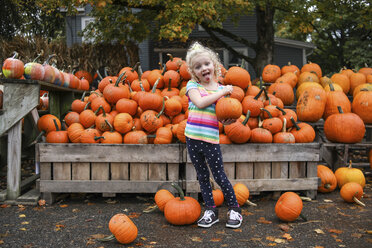 Portrait of playful girl sticking out tongue while holding pumpkin - CAVF51866