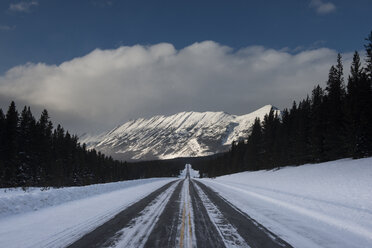 Snow covered road against mountains and cloudy sky - CAVF51911