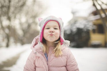 Portrait of cute girl puckering while wearing warm clothing during winter - CAVF51922