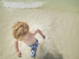 High angle view of shirtless boy running in sea - CAVF51928