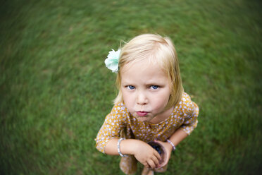 High angle portrait of girl eating blueberries while standing on grassy field - CAVF51961