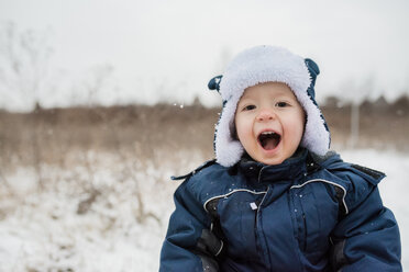 Porträt des niedlichen verspielten kleinen Jungen, der schreit, während er warme Kleidung im Winter trägt - CAVF51971