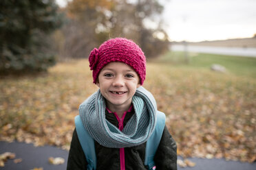 Porträt eines Mädchens, das im Herbst auf der Straße steht - CAVF51986
