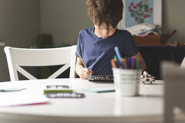 Boy making greeting card on table at home - CAVF52009