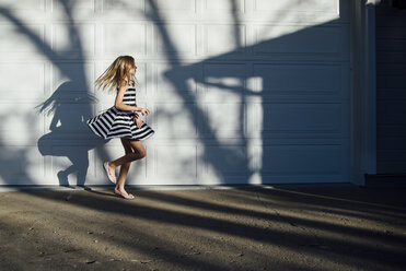 Seitenansicht eines tanzenden Mädchens bei einer Garage - CAVF52027