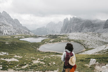 Weiblicher Wanderer mit Rucksack, der die Aussicht betrachtet, während er vor den Bergen steht - CAVF52054