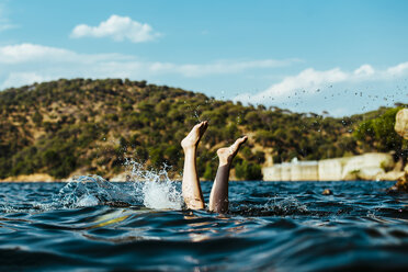 Low section of person swimming in sea against blue sky - CAVF52140