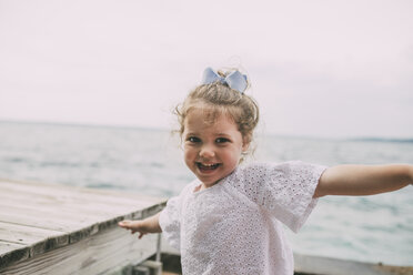 Porträt eines fröhlichen Mädchens gegen Meer und klaren Himmel - CAVF52142