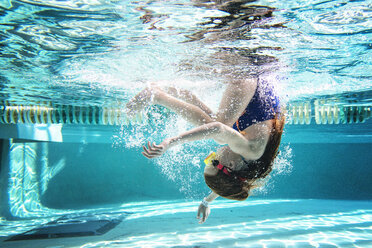 Mädchen schwimmt in voller Länge unter Wasser im Pool - CAVF52323