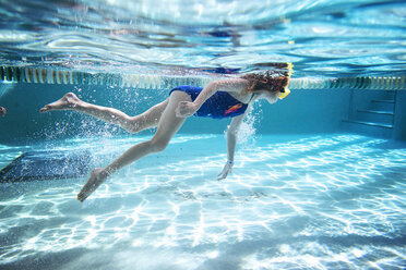 Seitenansicht eines Mädchens, das unter Wasser im Pool schwimmt - CAVF52324