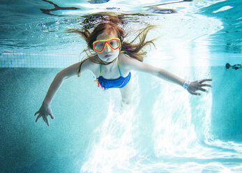 Porträt eines Mädchens, das unter Wasser im Pool schwimmt - CAVF52325