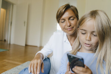 Mutter und Tochter schauen gemeinsam auf ihr Smartphone - KNSF05065