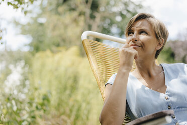 Porträt einer im Garten auf einem Stuhl sitzenden Frau - KNSF05066