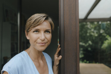 Portrait of confident woman at French window - KNSF05074