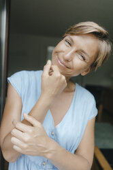Porträt einer lächelnden Frau am französischen Fenster - KNSF05080