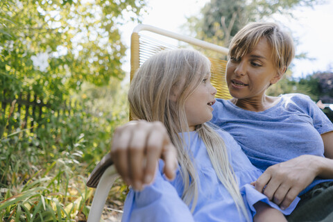 Mutter und Tochter entspannen sich im Garten, lizenzfreies Stockfoto