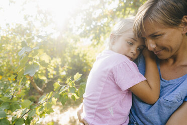 Happy mother carrying daughter in garden - KNSF05104