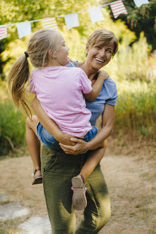 Glückliche Mutter mit Tochter im Garten, lizenzfreies Stockfoto