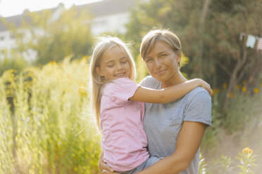 Portrait of smiling mother carrying daughter in nature - KNSF05131