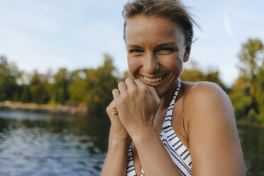 Porträt einer glücklichen Frau in einem Bikini an einem See - KNSF05143