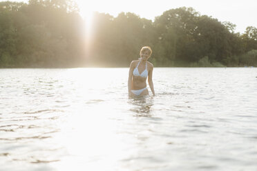 Portrait of happy woman wearing a bikini in a lake - KNSF05151