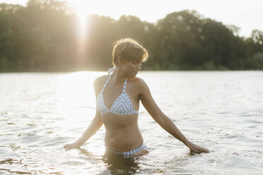 Young blond woman wearing bikini at the beach and looking at