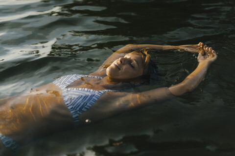 Porträt einer Frau, die in einem See schwimmt, lizenzfreies Stockfoto