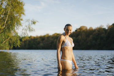 Portrait of smiling woman wearing a bikini in a lake - KNSF05158