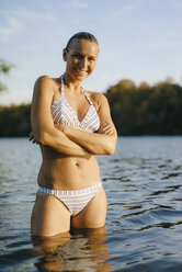 Portrait of smiling woman wearing a bikini in a lake - KNSF05160