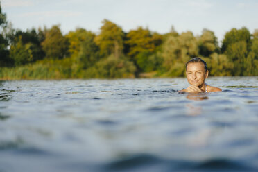 Portrait of smiling woman swimming in a lake - KNSF05161