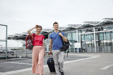 Lächelndes Paar vor dem Flughafen - RHF02205